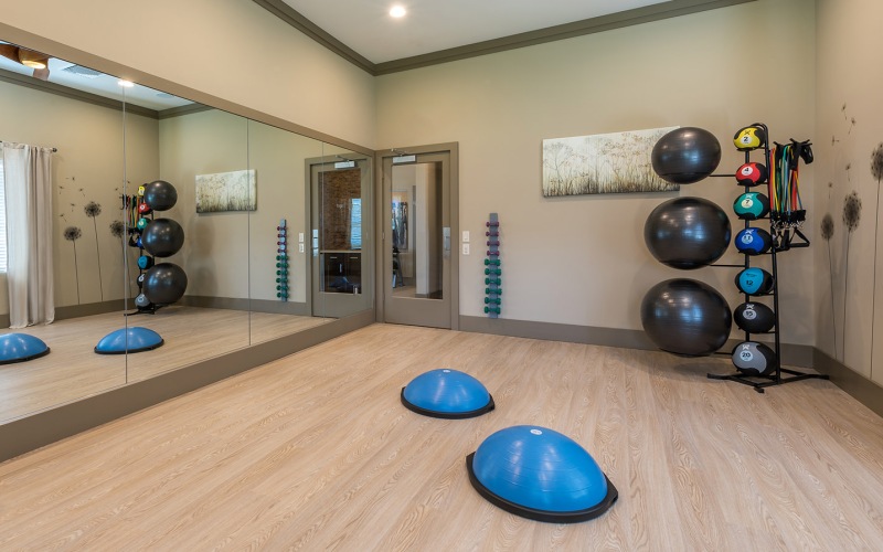 Large yoga room with a large window and weighted balls.